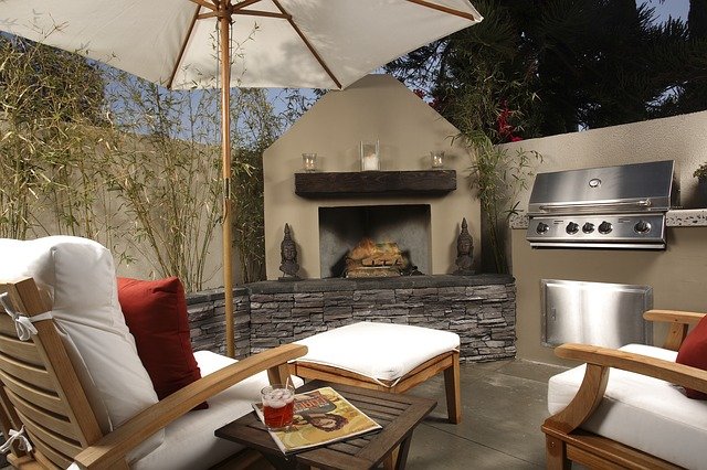 Outdoor Kitchen with Grill in Masonry Unit, Fireplace, & Seating Area
